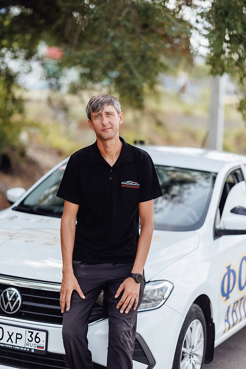 Инструктор опирается на машину